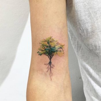 Green tree tattoo on the right arm