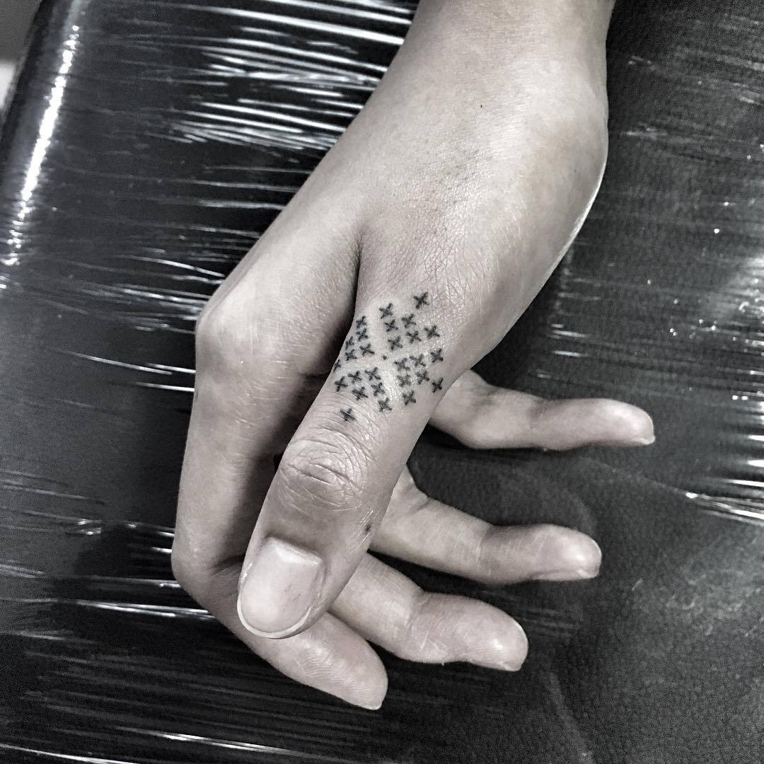 Hand poked ornamental tattoo on the thumb