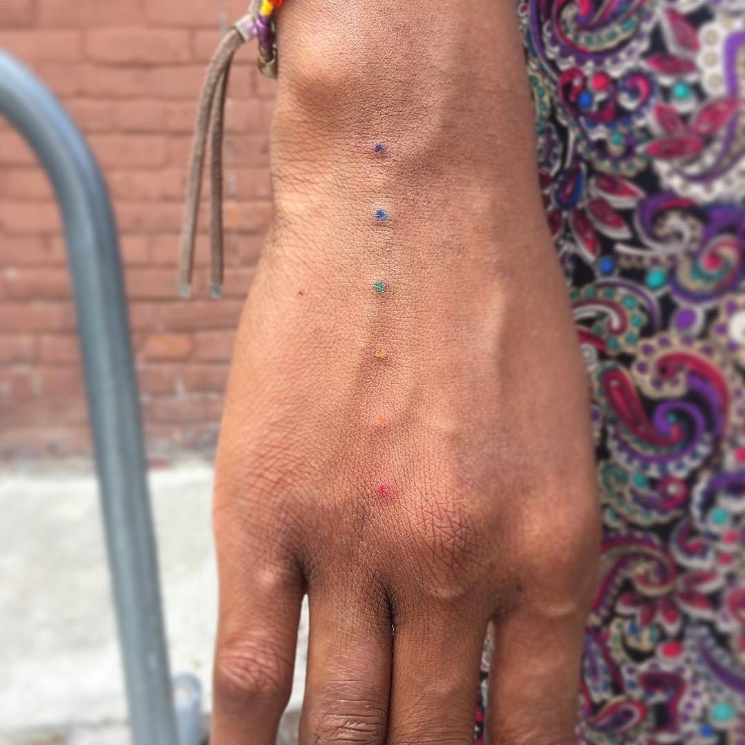 Hand poked rainbow dots tattoo