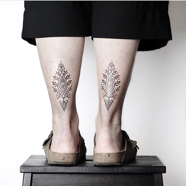 Matching ornamental tattoos on calves
