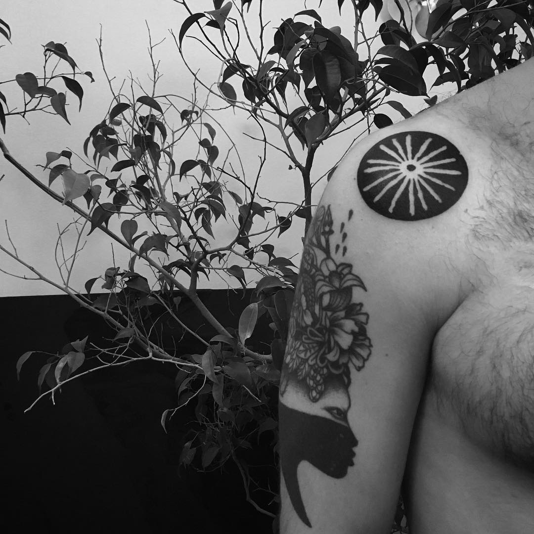 Negative space circular sun tattoo