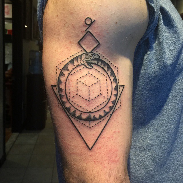 Ouroboros and geometric shapes tattoo on the arm