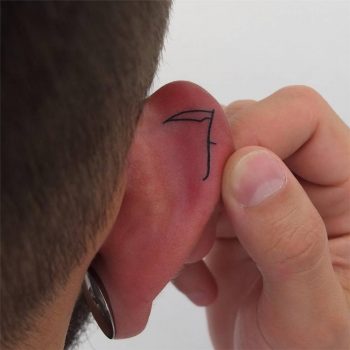 Scythe tattoo on the ear