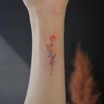Small watercolor flower tattoo on the inner wrist