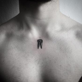 Small black tooth tattoo