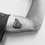 Small boat tattoo on the bicep