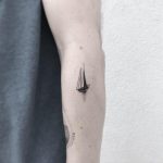 Small boat tattoo on the left forearm