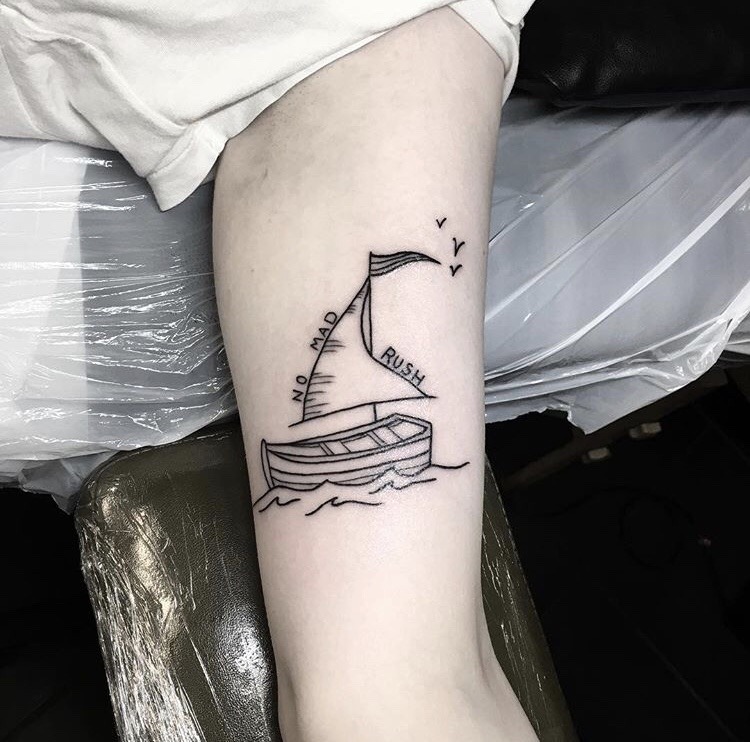 Small sailing boat tattoo on the arm