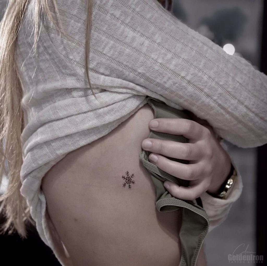 Small snowflake tattoo on the rib