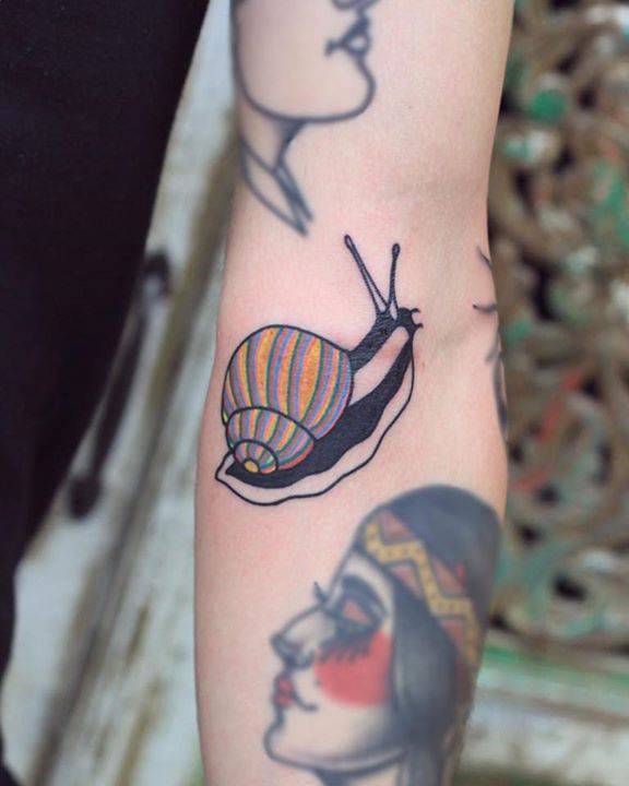 Snail tattoo on the left arm