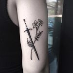 Sword and flower tattoo on the arm