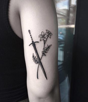 Sword and flower tattoo on the arm