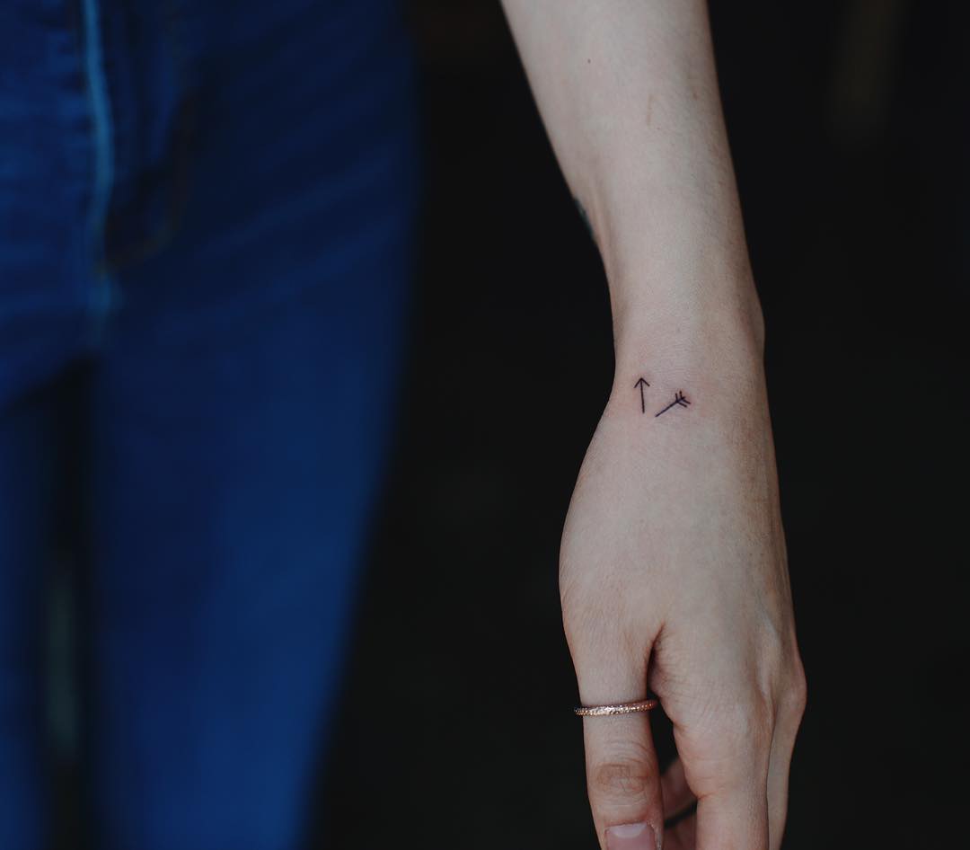 Tiny arrows tattoo on the hand