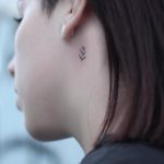 Tiny fern leaf tattoo on the neck