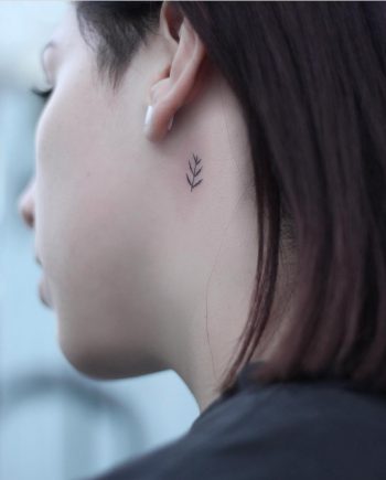 Tiny fern leaf tattoo on the neck
