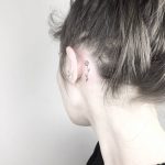 Tiny tulip tattoo behind the left ear