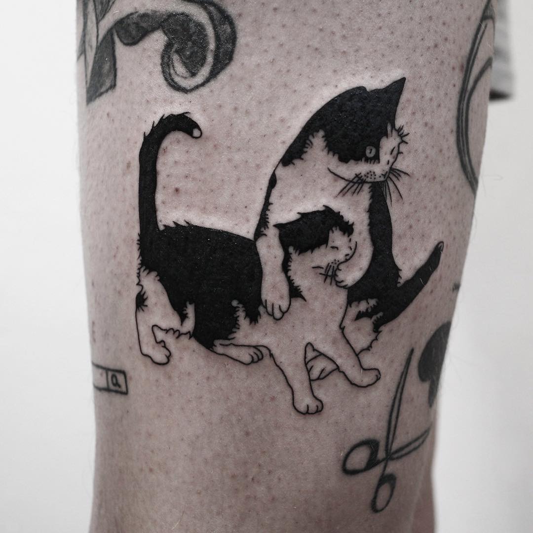 Two cats tattoo on the leg