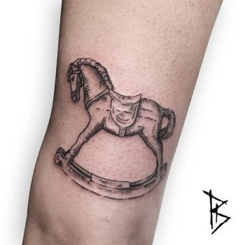 Woodcut style rocking horse tattoo
