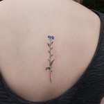 Dainty colored flower tattoo by yuni