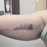 Gradient mountains tattoo on the bicep