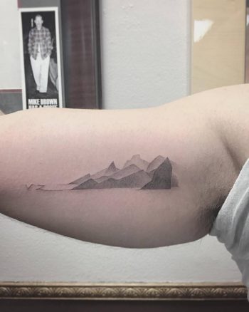 Gradient mountains tattoo on the bicep