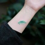 Hand poked flying green car tattoo