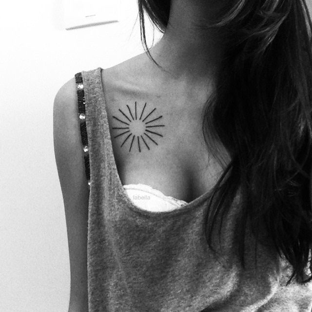Minimalist sun tattoo on the collarbone