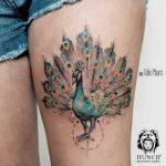 Peacock tattoo on the thigh