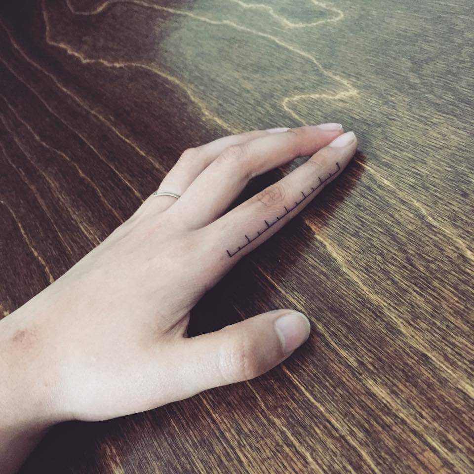 Ruler tattoo on the index finger