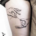 Thread holding hands tattoo