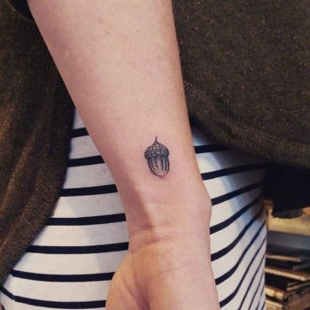 Tiny acorn tattoo on the wrist