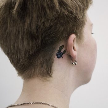 Tiny blueberry tattoo behind the ear