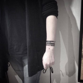Black wristband tattoo on the left wrist