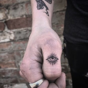 Blackwork eye tattoo on the thumb