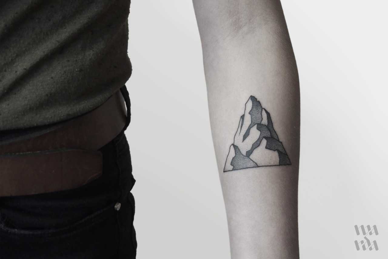 Blackwork mountain tattoo on the left forearm