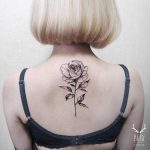 Blackwork rose tattoo on the upper back