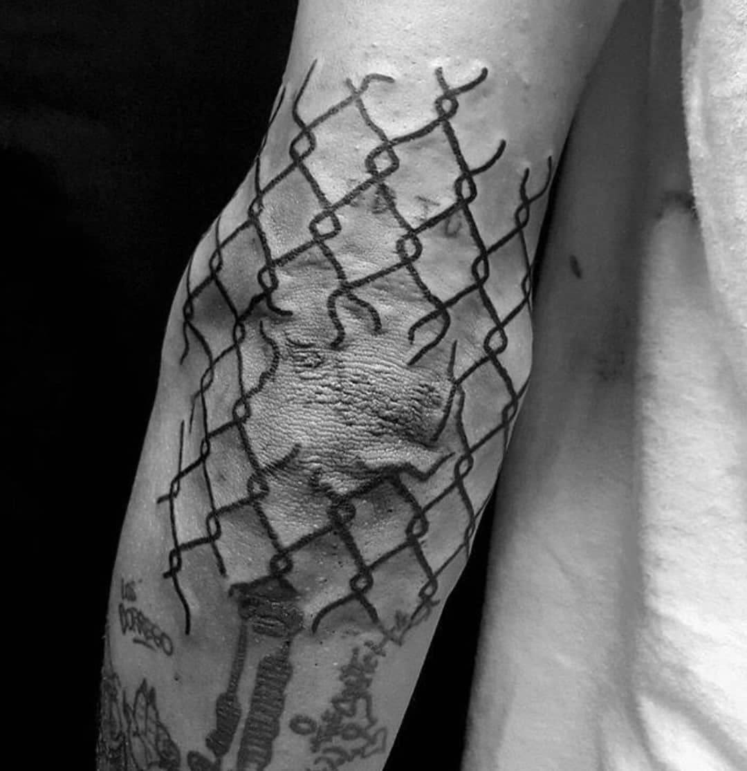 Broken fence tattoo on the elbow