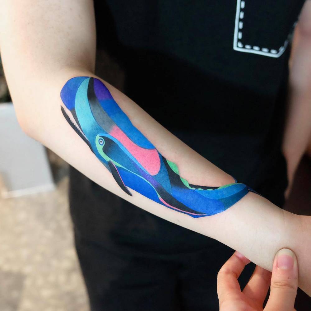 Colorful whale tattoo on the forearm