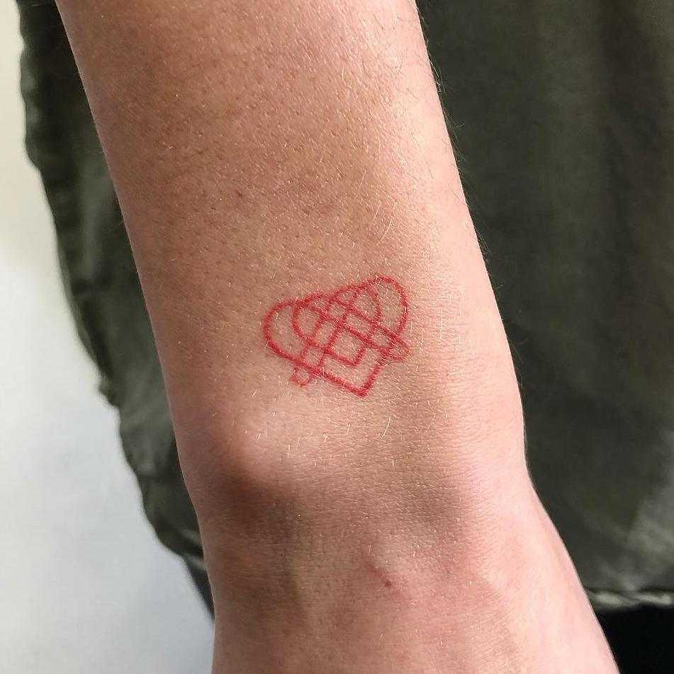 Custom hand-poked red heart tattoo