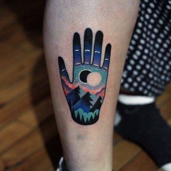 Double exposure hand and landscape tattoo