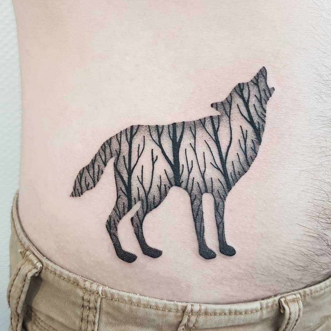 Double exposure wolf and forest tattoo