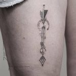 Geometric arrow tattoo on a thigh