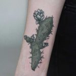 Green cactus tattoo on the right forearm