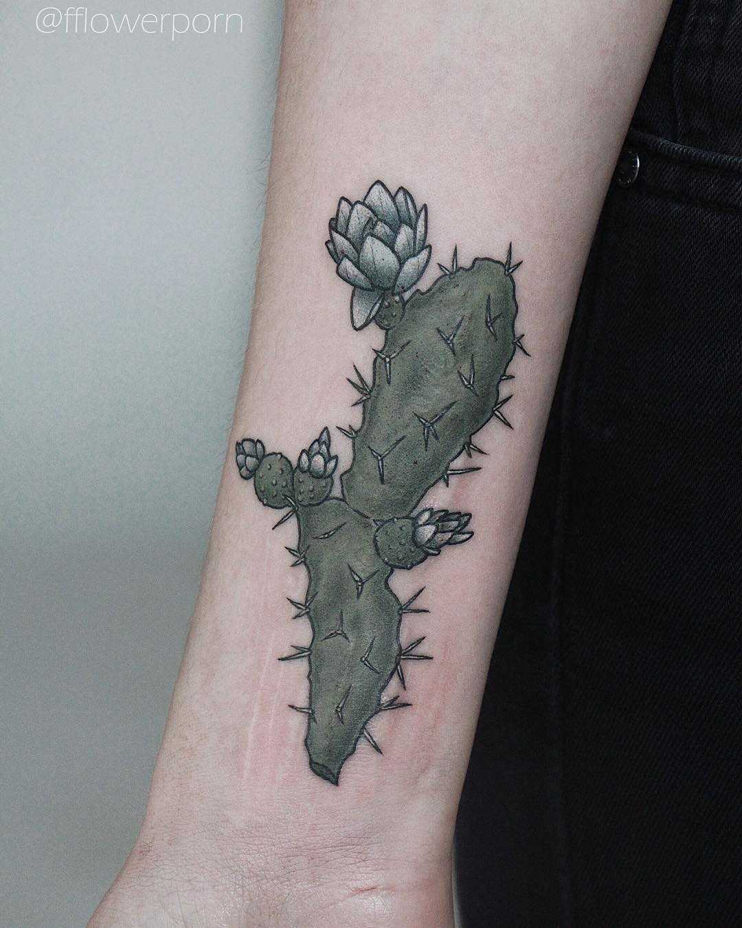 Green cactus tattoo on the right forearm