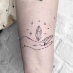 Hand-poked hand and crystal tattoo