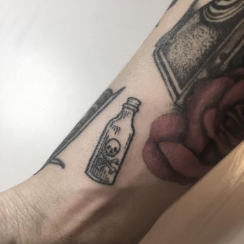 Hand-poked little poison bottle tattoo