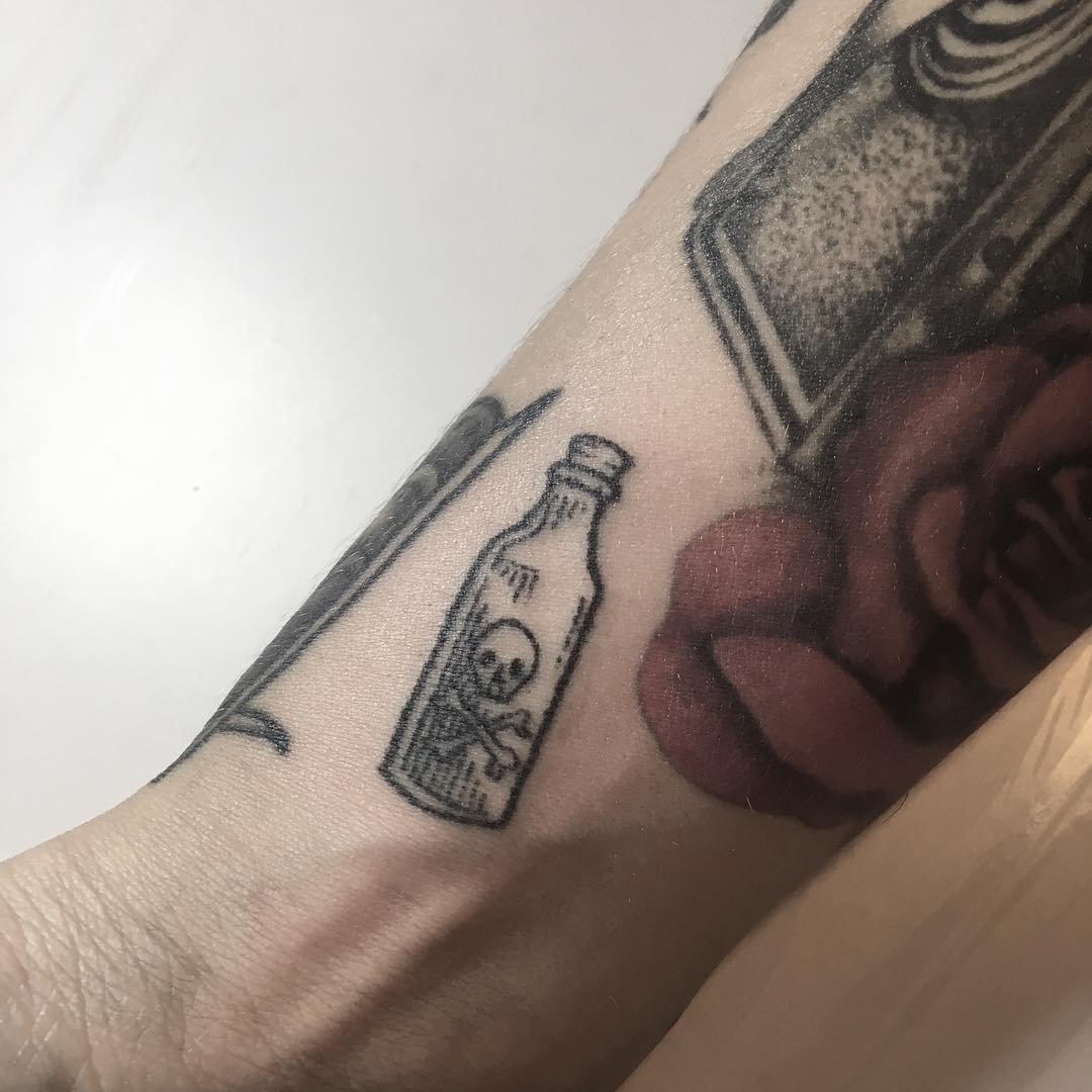 Hand-poked little poison bottle tattoo
