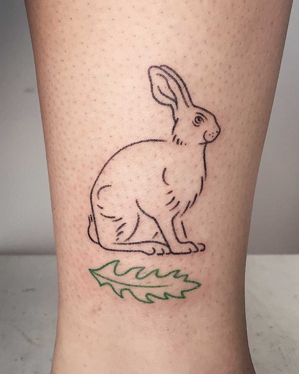Hand-poked rabbit and leaf tattoo