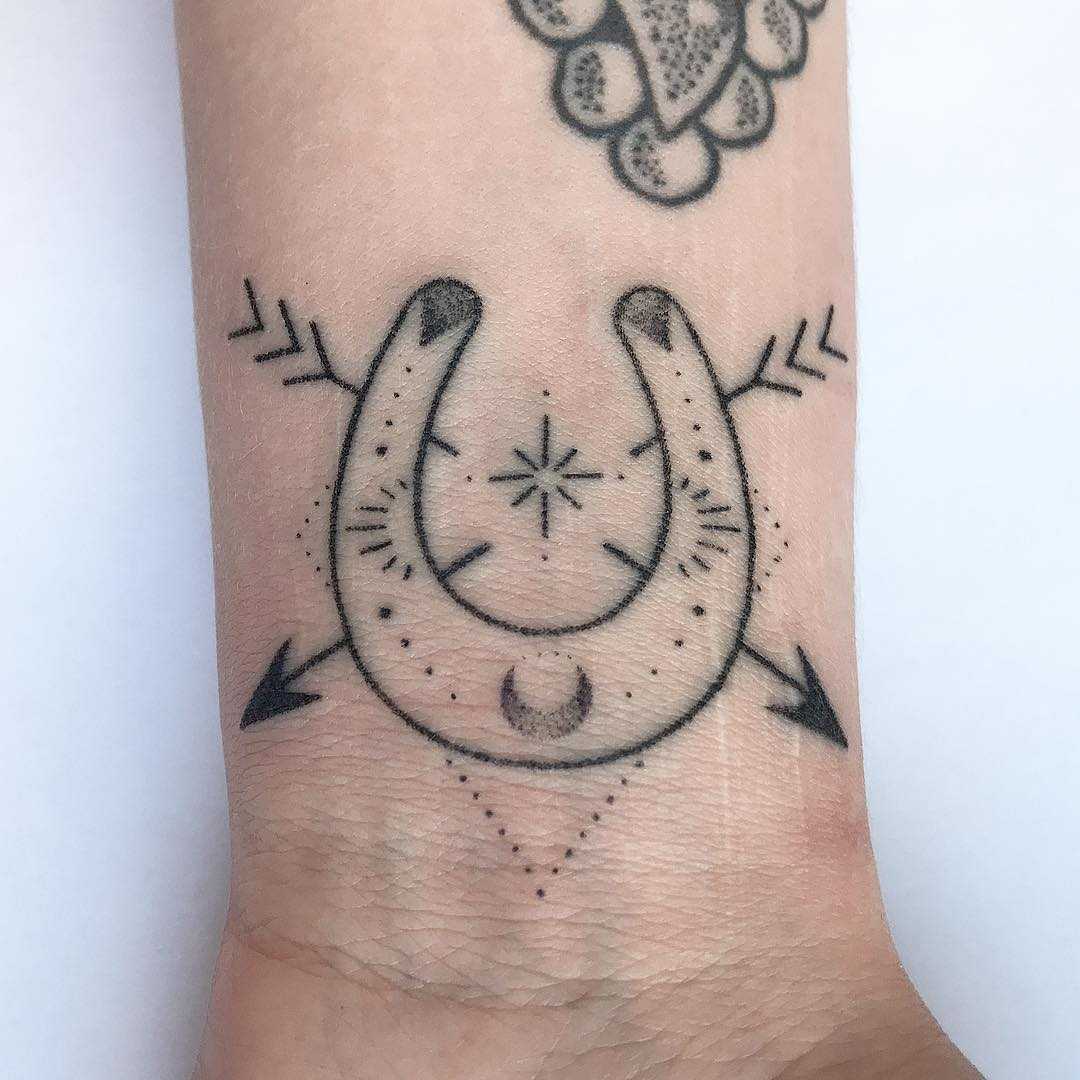 This is a horseshoe and flowers. Apparently. : r/shittytattoos