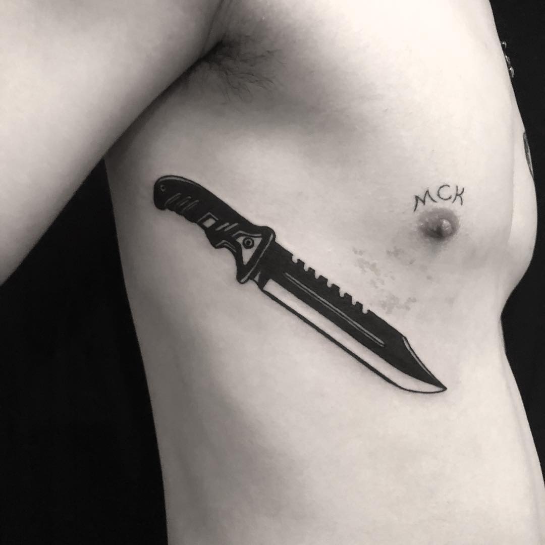 Jungle knife tattoo on the rib